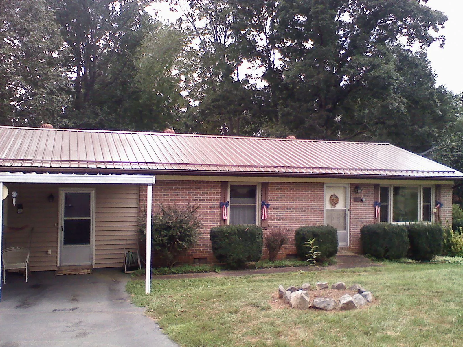 Bronze metal roof and carport on a brick ranch home — Roof Repair work by our crew in Plainville